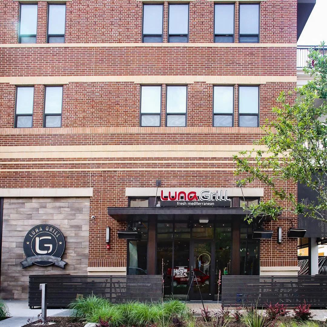 A brick exterior with the wordmark over the door and the badge as a wall medallion
