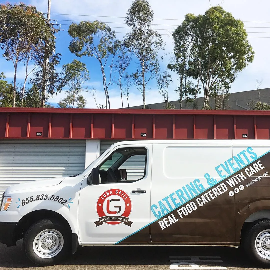 A catering van carrying the badge and the line real food catered with care