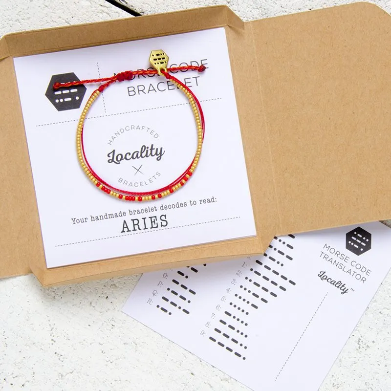 An opened kraft Locality box with a bracelet and its cards arranged inside.